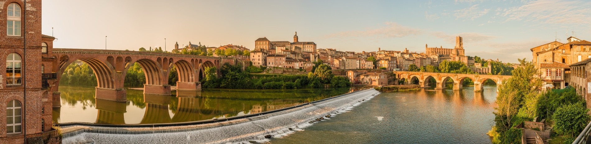 Panorama d’Albi au petit matin : le Tarn, la chaussée des moulins, le Pont-Vieux et la cathédrale Sainte-Cécile.