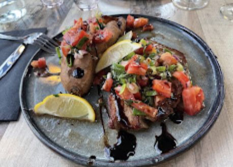 Assiette de viande grillée nappée d’un tartare de tomates et de réduction balsamique.